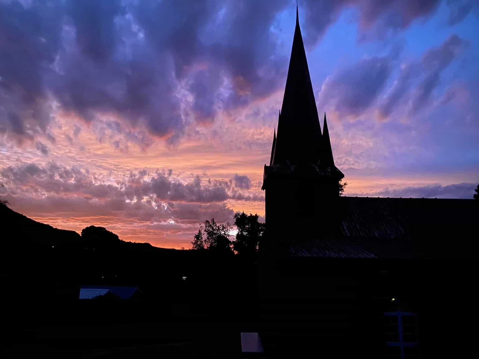 Church steeple silhouetted against a dramatic sunset sky in the Makhoarane region
