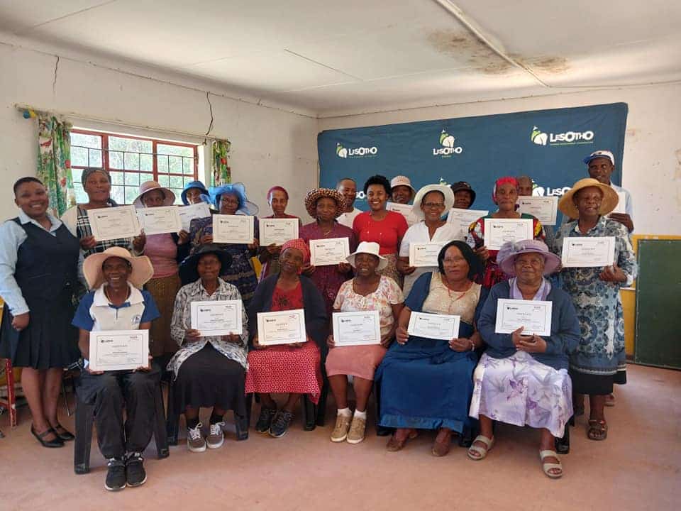 Women proudly holding their certificates after completing a training programme